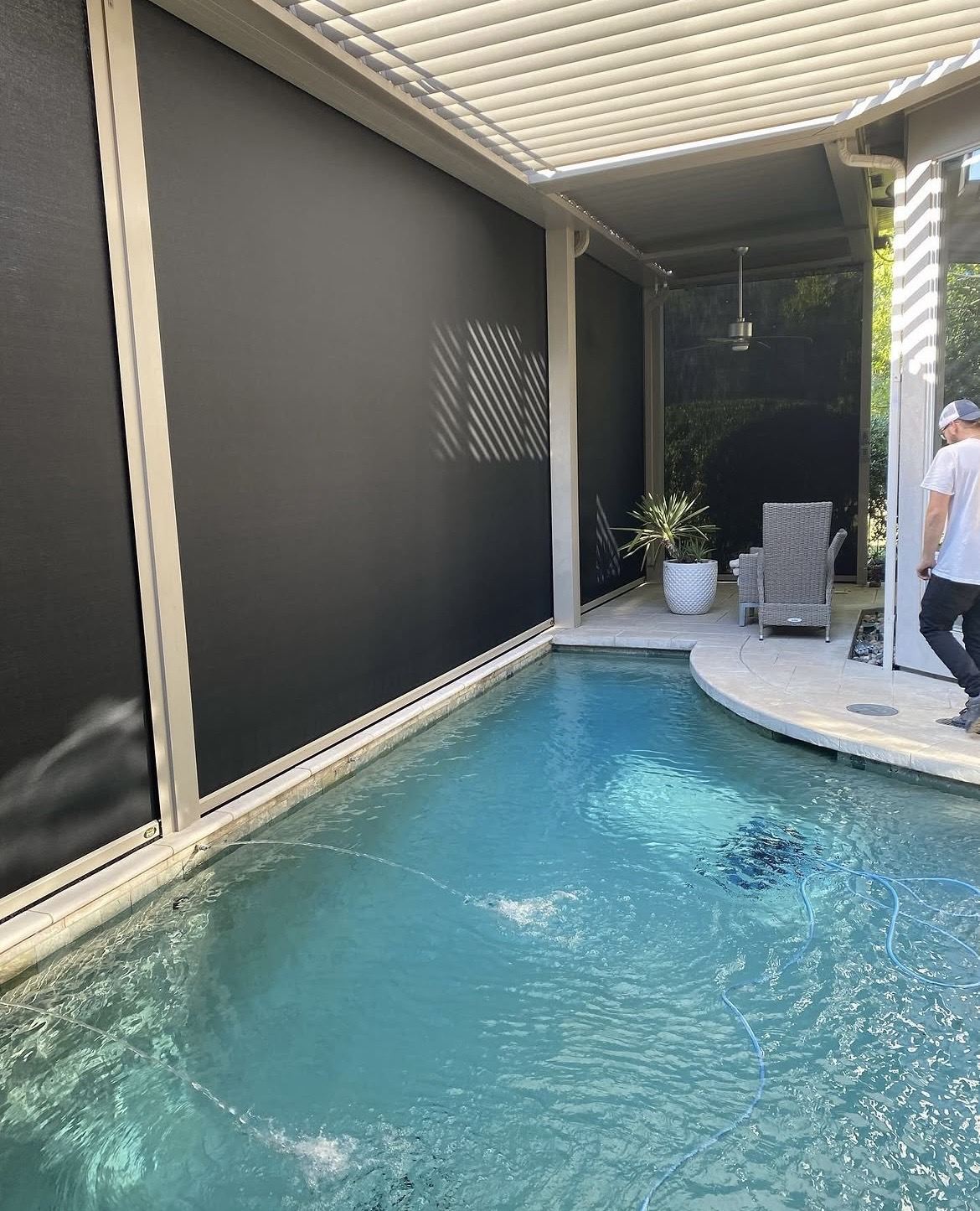 Poolside patio enclosed by motorized screens