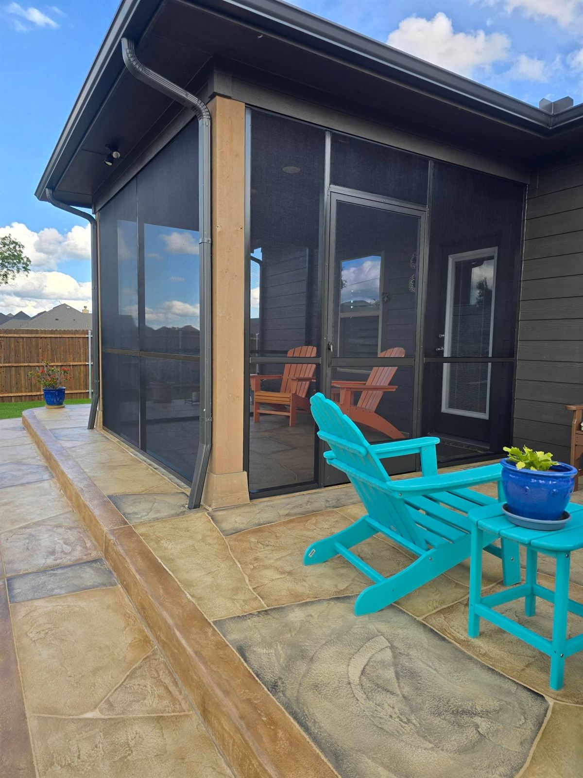 Screen room patio with Adirondack chairs on a DFW backyard