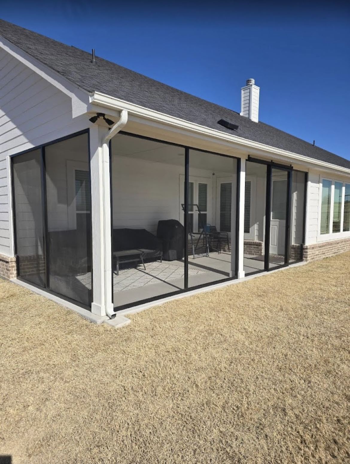 Long enclosed screened porch along the back of a DFW home