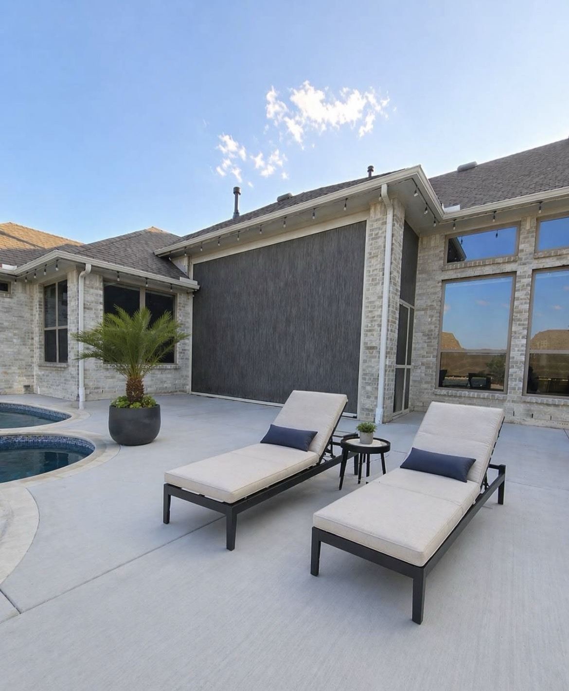 Motorized patio screen alongside a DFW pool and lounge chairs